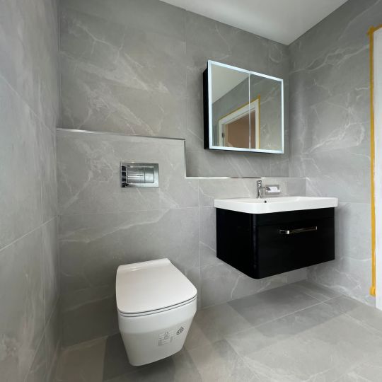 Wall-hung toilet and sink in a bathroom designed and built by Piha Plumbing and Bathroom Installations
