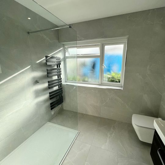 Large shower with wall-mounted towel rail