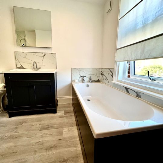 Bath and sink with cabinet below