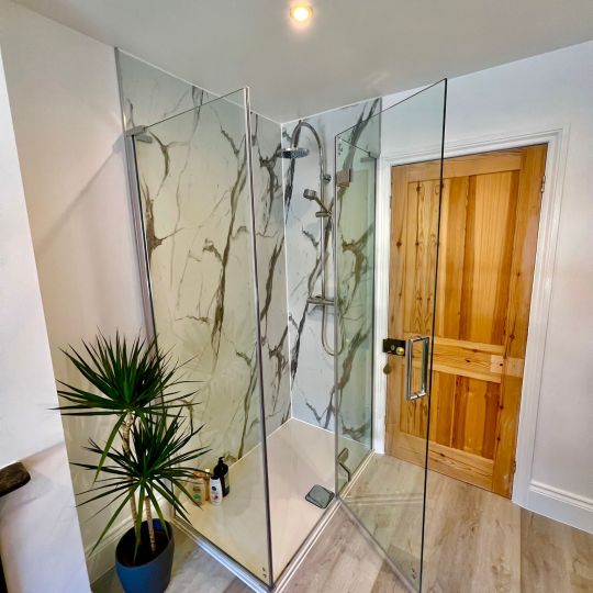 Shower in bathroom with wood effect tiled floor