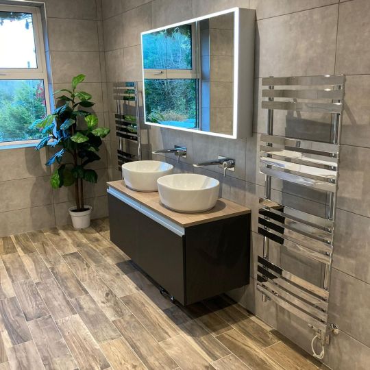 Twin bathroom sinks with lit bathroom mirror