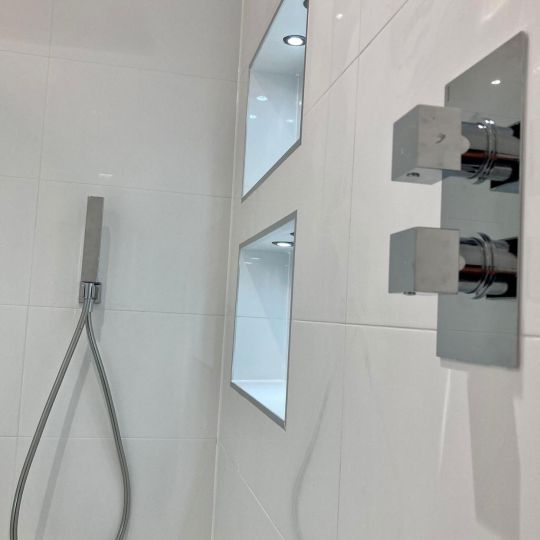 Mixer taps in chrome with white tiled wall
